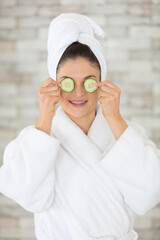 beautiful young woman is getting facial mask at spa