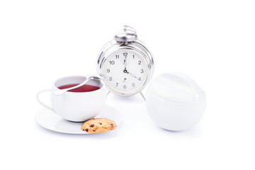Cup of tea with chocolate chip cookies and an alarm clock