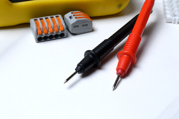 electrical terminal blocks and multimeter probes on a light background. close-up.