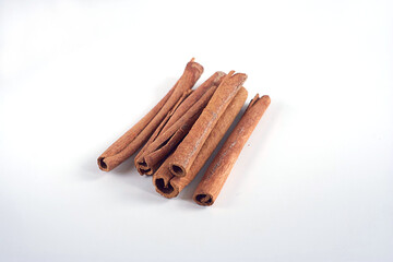 Cinnamon sticks lie on a white table