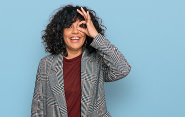 Young hispanic woman wearing business clothes doing ok gesture with hand smiling, eye looking through fingers with happy face.