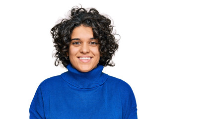 Young hispanic woman with curly hair wearing turtleneck sweater with a happy and cool smile on face. lucky person.