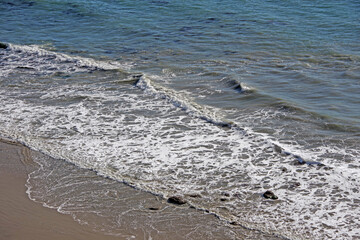 High angle view of waves at the water edge of an ocean beach