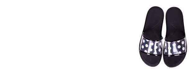 Black slippers with dotted pattern, isolated on white background.