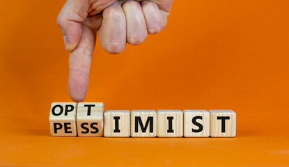 Pessimist or optimist symbol. Businessman turns cubes and changes the word 'pessimist' to...