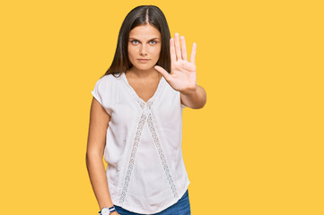 Young caucasian woman wearing casual clothes doing stop sing with palm of the hand. warning expression with negative and serious gesture on the face.