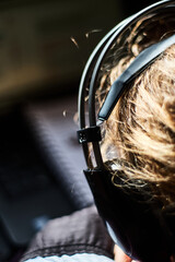 A woman working on a laptop and has headphones on