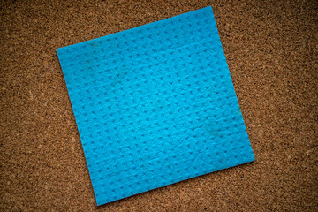 Fototapeta premium Blue sponge for dishes on the cork table