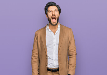 Young hispanic man wearing business clothes angry and mad screaming frustrated and furious, shouting with anger. rage and aggressive concept.