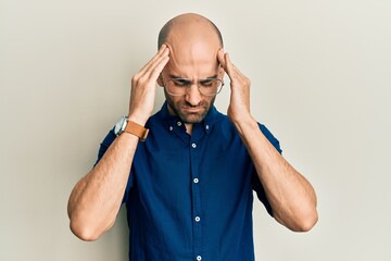 Young hispanic man wearing casual clothes and glasses suffering from headache desperate and stressed because pain and migraine. hands on head.