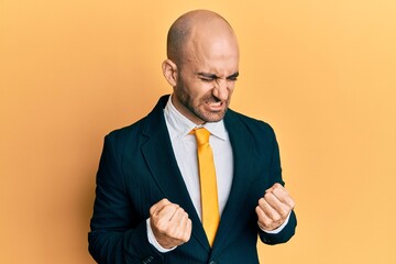 Young hispanic man wearing business suit and tie very happy and excited doing winner gesture with arms raised, smiling and screaming for success. celebration concept.