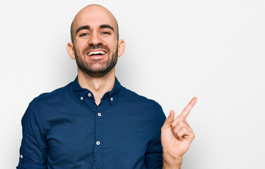 Fototapeta premium Young hispanic man wearing casual clothes with a big smile on face, pointing with hand finger to the side looking at the camera.
