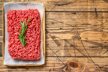 Fresh Raw mince beef, ground meat on butcher paper. wooden background. Top view. Copy space
