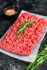 Fresh Raw mince beef, ground meat on butcher paper. Black background. Top view