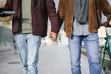 Two boys holding hands while walking.