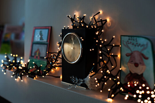 Clock with burning garland light christmas decor. Interior image