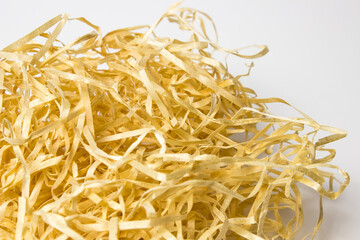 beige nest of a wooden bird made of paper shavings with quail eggs on a white background with a place for text and inscriptions.