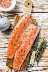 Raw salmon or trout sea fish fillet with spices and herbs. White wooden background. Top view