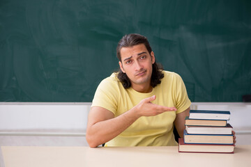 Young male student preparing for exams in the classroom