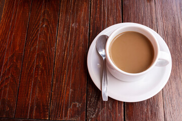 Top view of cup of coffee filled with latte on rustic wooden table.