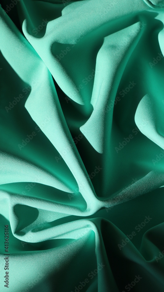 Wall mural beautifully crumpled dense fabric with the texture of folds creating the image of a flower, the mint