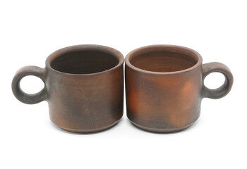Two clay (ceramic) cups (mugs) for milk or tea isolated on a white background. Pottery production in the city of Suzdal, Vladimir region.