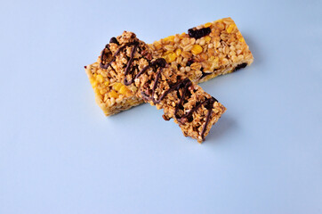 Two granola bars lie on top of each other on a blue table view from above with a copy space. High quality photo