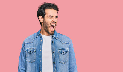 Young hispanic man wearing casual clothes angry and mad screaming frustrated and furious, shouting with anger. rage and aggressive concept.