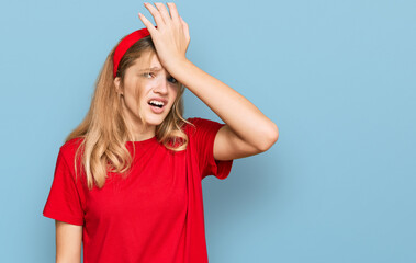 Beautiful young caucasian girl wearing casual red t shirt surprised with hand on head for mistake, remember error. forgot, bad memory concept.