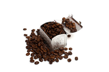 Roasted coffee beans in a small metal chest around it. Isolate on a white background. Copspace