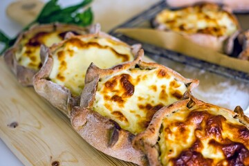 Rye dough pies with potato filling. National Karelian food wicket close-up on a wooden board. Alternative flour baked goods without sugar and gluten, authentic baked goods