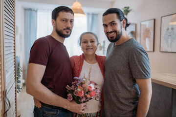 Sons congratulate mom on the holiday. Men visiting their beloved mother on a holiday