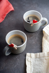 two cups of coffee with hearts attached on the table. Selective focus. Copy space for a text.