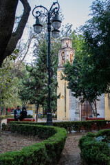 Naklejka premium Old Mexican Church surrounded by trees in Coyoacan