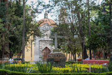 Fototapeta na wymiar Stone cross in the middle of a park from Coyoacan