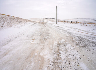 Country road on the prairie during winter ice fog