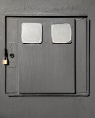 Gray box for electric meter with padlock on a wall