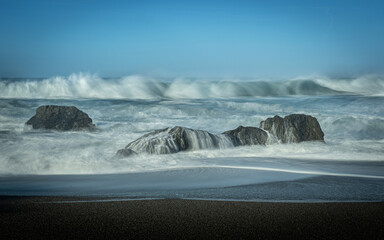 Waves coming towards the beach, long exposure on a blue sky day with no clouds, and lots of copy-space, Schoolhouse Beach in Sonoma County, CA, USA