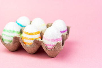 Colorful Easter eggs on a pink background. Copy space. Celebrating Easter