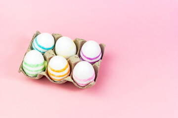 Colorful Easter eggs on a pink background. Copy space. Celebrating Easter