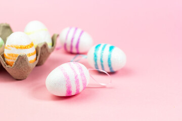 Fototapeta premium Colorful Easter eggs on a pink background. Copy space. Celebrating Easter