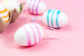 Colorful Easter eggs on a pink background. Copy space. Celebrating Easter