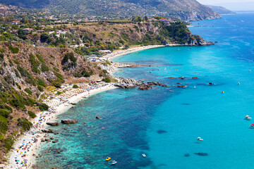 Amazing tropical panoramic view of turquoise gulf bay, sandy beach, green mountains and plants.