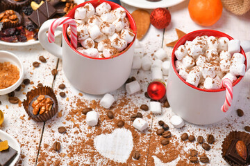 sweet food top view background for merry christmas or new year holiday decoration - chocolate candies, tangerines, cookies, marshmallow and cocoa latte on white wood