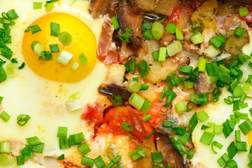 baked mixed vegetables and eggs close view, baking tray with tomatoes, broccoli and spices, home cooking