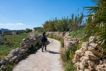 Fototapeta na wymiar Woman with backpack hiking in Malta
