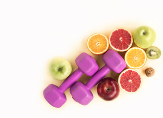 Fruits and dumbbells for a healthy lifestyle Top view on a sports background