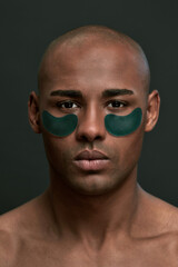 Serious man with dark green under eye patches