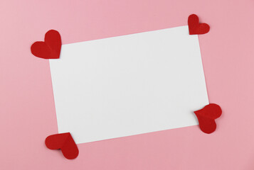 A blank white card for filling text and with handmade heart-shaped paper. Valentine's Day Concepts.