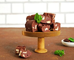 Sliced homemade fudge chocolates made from dark chocolate, condensed milk and hazelnuts on a wooden...